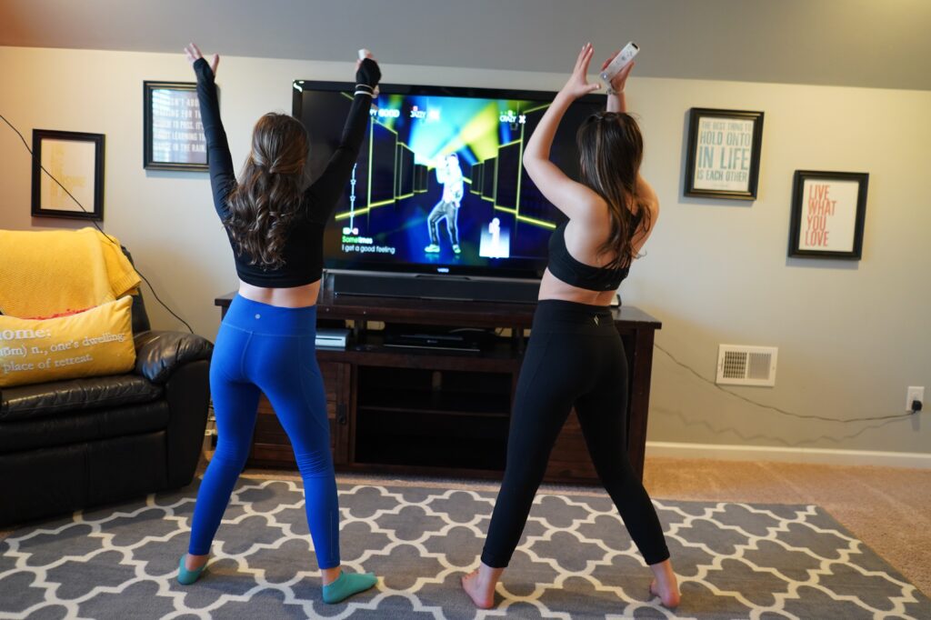 Girls play Just Dance on Wii. There’s nothing like some upbeat tunes to shake up a dull day. So crank up the volume and burn some of that bouncing-off-the-walls energy with a family dance party. 