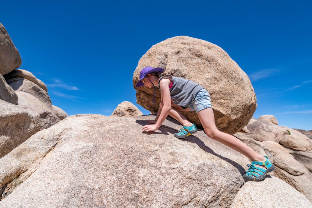 Girl climbs up stone mountain. If your family lives near a mountain then go climb it! Bearing safety in mind with younger kids, you may want to avoid spots that are off-the-grid and instead stick to official city or state parks with marked trails. Enjoy the view from the top! 