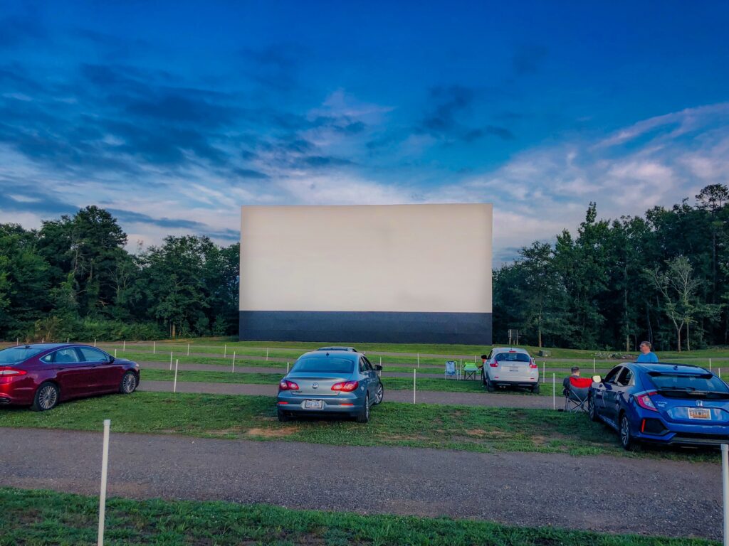 Image of movie screen at at Drive-In Movie Theater. Drive-ins are making quite a comeback as one of the best ways to enjoy a summer blockbuster while social distancing! We are lucky enough to have one within driving distance that offers movies in high definition. 