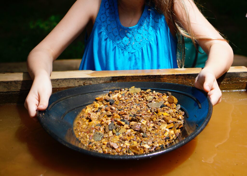 Gir pans for gold. Want a rewarding outing? Try your hand at gem mining, sluicing or panning for gold. Look for a local mine or park in your area. Some even offer buckets with guaranteed treasure inside.