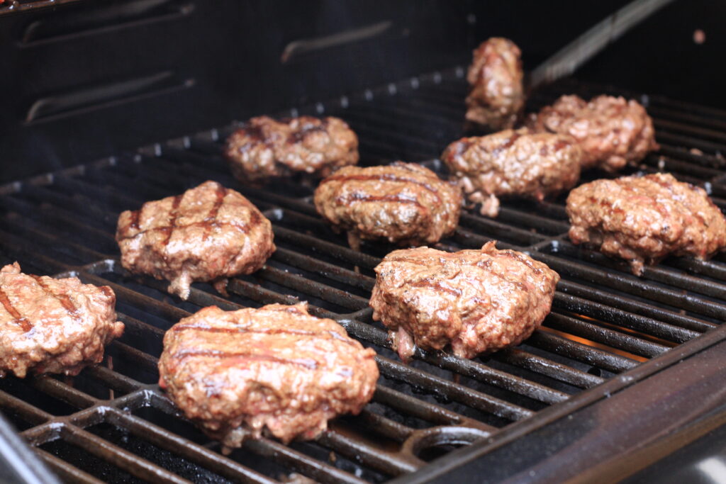 Image of hamburgers being cooked on a grill. Grilling is always a good idea in the summer time. Not only does it make anything from burgers and hot dogs to veggies and shrimp taste that much better, it keeps the heat od cooking out of your house. Take the opportunity to teach older kids this summer to safely master the grill. 