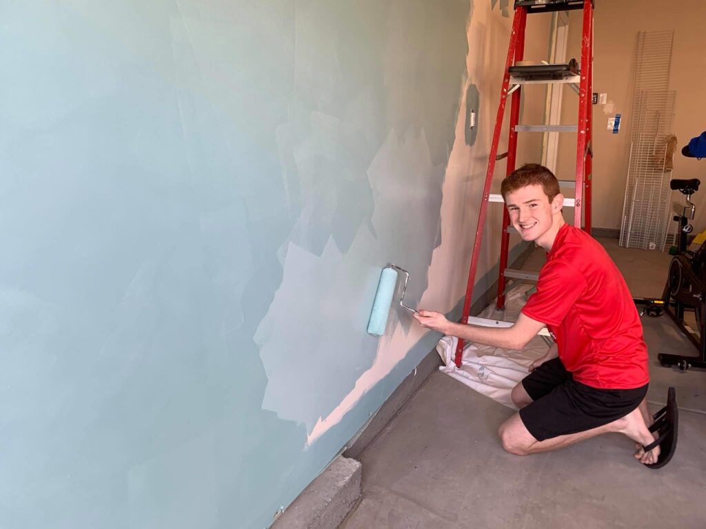 Teenage boy paints wall as part of room make-over. - Safe Summer Bucket List – 100 Ways to Have Fun This Summer While Social Distancing