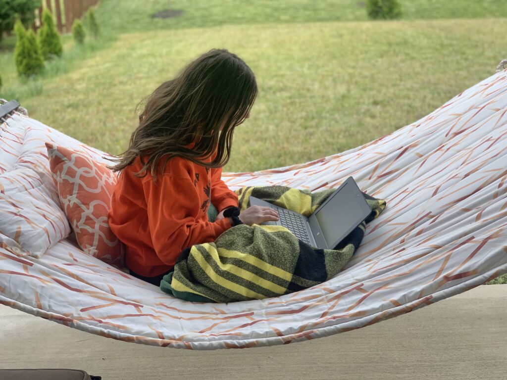 Girl sitting in hammock works on online class.  Just because school is out doesn’t mean learning has to stop. Take this time to learn a new skill or hobby, study a new subject or re-learn an old one.