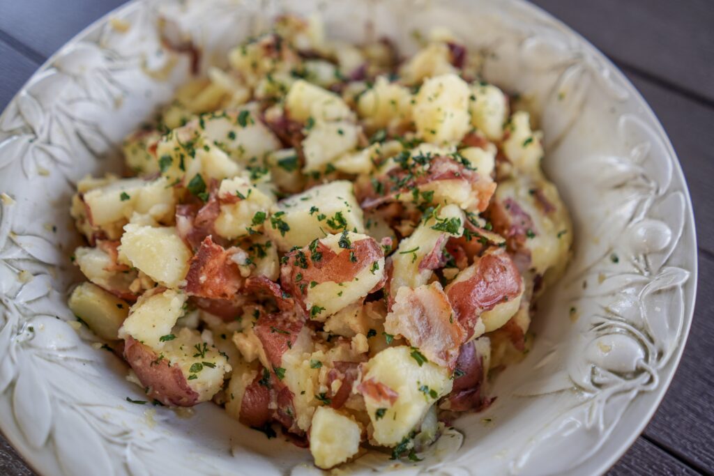 Bowl of homemade german potato salad. Pick another state or country with food you like, cook it and listen to music from that location during dinner. This is especially fun if you had planned a trip to that destination. You'll be inspired and ready to go when travel opens back up! 