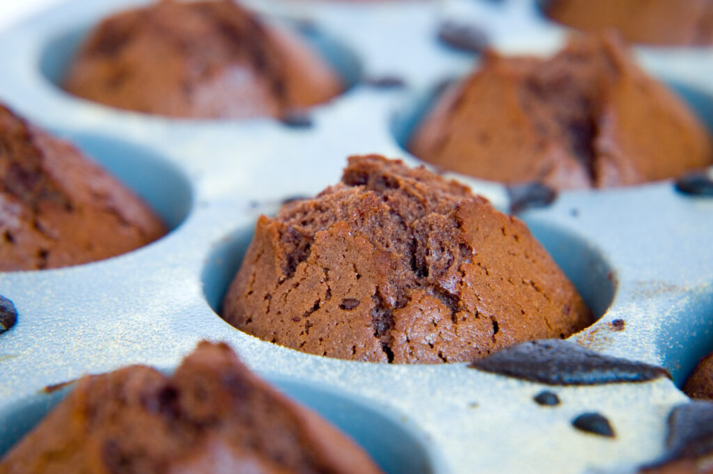 Close up image of chocolate cupcakes. Create a challenge for your family, where you attempt to recreate an intricate dessert or create a shortlist of ingredients that must be used in a meal and see what your family can whip up. - Safe Summer Bucket List – 100 Ways to Have Fun This Summer While Social Distancing