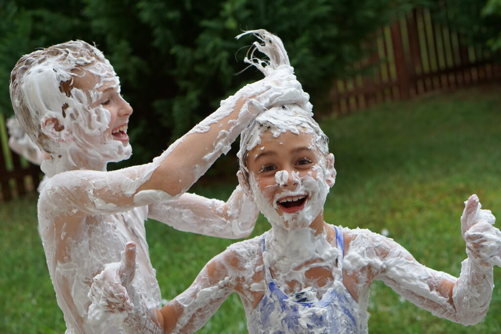 Kids covered from head to toe in shaving cream get messy. - Safe Summer Bucket List – 100 Ways to Have Fun This Summer While Social Distancing