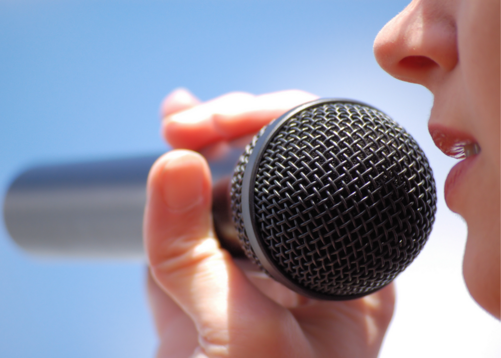 Close-up of girl singing into microphone. Check out the Disney Family Singalongs on Disney+ or make an Amazon playlist and singalong with the lyrics on your TV. Another fun option is to  sing some sweet harmonies with your very own karaoke machine.